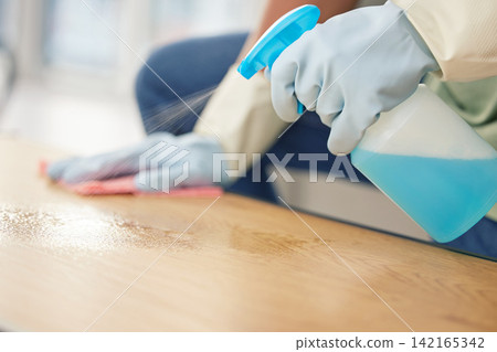 Cleaning, hands in gloves and spray at table in living room of home for domestic chores or housework. Bacteria, bottle and product to wipe with person in apartment for disinfection or housekeeping Cleaning, hands in gloves and spray at table in living room of home for domestic chores or housework. Bacteria, bottle and product to wipe with person in apartment for disinfection or housekeeping 142165342
