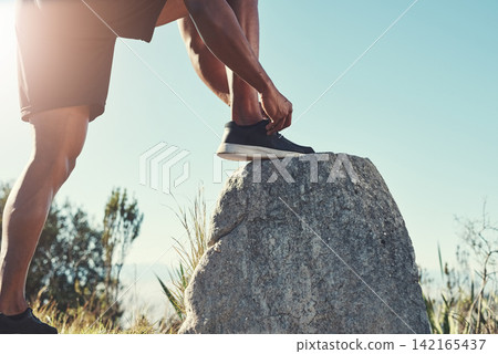 Runner, legs and tying laces on rock, outdoors and prepare for cardio and marathon training. Man, stone and shoes for exercise or sports in nature, getting ready and feet for workout or athlete Runner, legs and tying laces on rock, outdoors and prepare for cardio and marathon training. Man, stone and shoes for exercise or sports in nature, getting ready and feet for workout or athlete 142165437