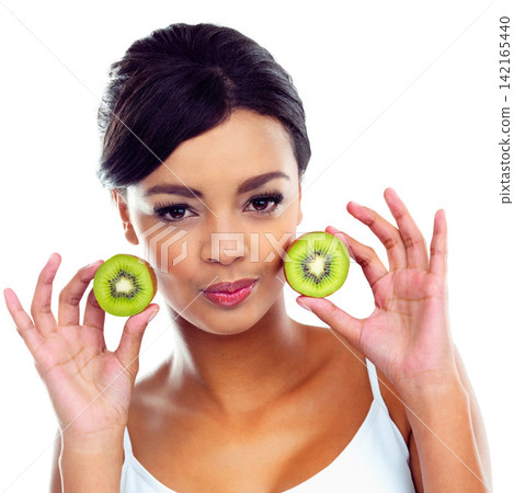 Portrait, diet and woman with kiwi, nutrition and sustainable eating to lose weight in studio. Citrus fruit, face and girl with fresh food for detox, vitamin c and gut health on white background. 142165440