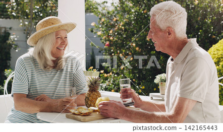 Senior, couple or pineapple on patio with water for retirement, planning vacation for anniversary. Husband, wife or old in garden for talk with drink, sunshine in summer with partner in home for chat Senior, couple or pineapple on patio with water for retirement, planning vacation for anniversary. Husband, wife or old in garden for talk with drink, sunshine in summer with partner in home for chat 142165443
