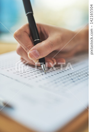 Woman, hand and writing a quiz with choice on clipboard for exam assessment, test and closeup of answer sheet. Paperwork, student and form with cross for learners license, education and scholarship 142165504