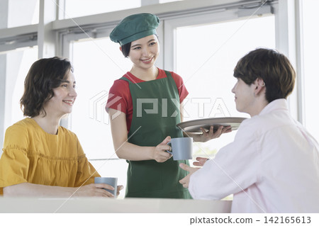 A young woman working in a cafe A young woman working in a cafe 142165613