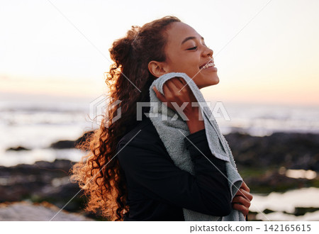 Woman, towel and break after fitness at the beach, happy for wellness and yoga outdoor with zen and calm, Pilates, fresh air and morning workout routine with young yogi in nature, ocean and exercise Woman, towel and break after fitness at the beach, happy for wellness and yoga outdoor with zen and calm, Pilates, fresh air and morning workout routine with young yogi in nature, ocean and exercise 142165615