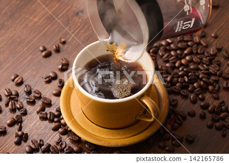 把咖啡倒進杯子裡 把咖啡倒進杯子裡 142165786