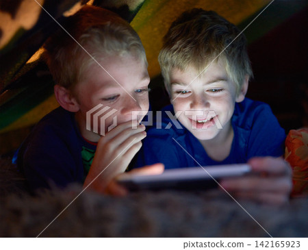 Smile, children and brothers on tablet in tent at home for game, movie or streaming cartoon online at night together. Happy kids, siblings and technology for app, internet or family relax in house Smile, children and brothers on tablet in tent at home for game, movie or streaming cartoon online at night together. Happy kids, siblings and technology for app, internet or family relax in house 142165923