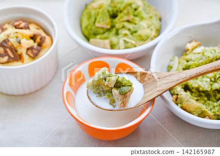 Scoop cookies to eat by dipping them in milk. 142165987