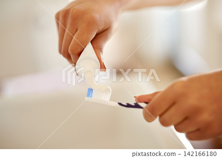 Toothpaste, hands and brush for dental health in bathroom with morning hygiene routine at home. Clean, wellness and person with oral care products for plaque, gums and fresh breath treatment at home. Toothpaste, hands and brush for dental health in bathroom with morning hygiene routine at home. Clean, wellness and person with oral care products for plaque, gums and fresh breath treatment at home. 142166180