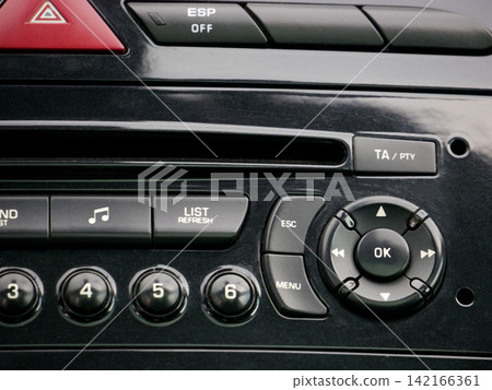 Car audio system center console with music buttons and navigation controls. Electronic interface panel for vehicle multimedia system. Dashboard interior technology for vehicle settings. Car audio system center console with music buttons and navigation controls. Electronic interface panel for vehicle multimedia system. Dashboard interior technology for vehicle settings. 142166361