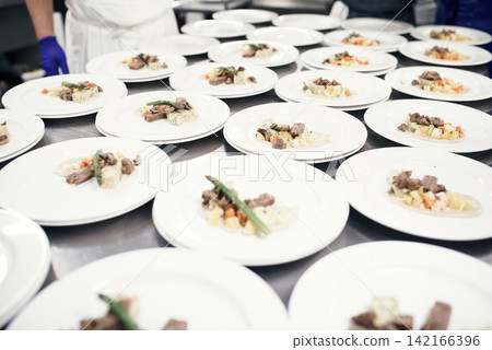 Food, plate and counter in industrial kitchen, meal servings and cuisine for customers in restaurant. Plating, serving and presentation inspection for quality, preparation and culinary or hospitality Food, plate and counter in industrial kitchen, meal servings and cuisine for customers in restaurant. Plating, serving and presentation inspection for quality, preparation and culinary or hospitality 142166396
