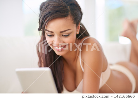Black woman, tablet and relax on sofa in lingerie for comfort or leisure, sexy and texting naughty message. Female person, home and online on internet for shopping underwear, happiness and browsing. Black woman, tablet and relax on sofa in lingerie for comfort or leisure, sexy and texting naughty message. Female person, home and online on internet for shopping underwear, happiness and browsing. 142166660