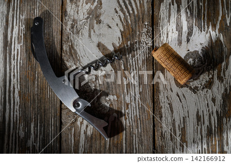 Corkscrew and Cork Resting on Rustic Wooden Surface in Gentle Light Corkscrew and Cork Resting on Rustic Wooden Surface in Gentle Light 142166912