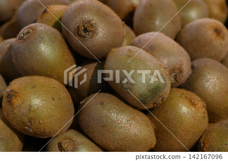 Fresh, ripe kiwis stacked neatly at a vibrant market stand, showcasing nature's bounty and the allure of healthy eating Fresh, ripe kiwis stacked neatly at a vibrant market stand, showcasing nature's bounty and the allure of healthy eating 142167096