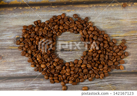 Creative coffee bean arrangement on weathered wood in a cozy setting evokes warmth and relaxation 142167123
