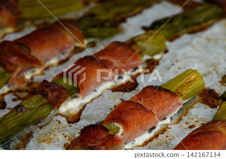 Delicious asparagus wrapped in savory meat, baked to perfection, ready for a delightful dining experience at home Delicious asparagus wrapped in savory meat, baked to perfection, ready for a delightful dining experience at home 142167134