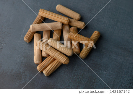 Crafted wooden blocks arranged creatively on a textured dark surface evoke a sense of artistry and simplicity in design Crafted wooden blocks arranged creatively on a textured dark surface evoke a sense of artistry and simplicity in design 142167142