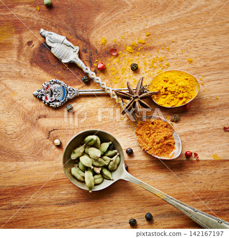 Spoons, spice and selection of cuisine for seasoning on kitchen table, turmeric and cardamom for meal. Top view, condiments and options for spicy cooking in Indian culture, cumin and food preparation Spoons, spice and selection of cuisine for seasoning on kitchen table, turmeric and cardamom for meal. Top view, condiments and options for spicy cooking in Indian culture, cumin and food preparation 142167197