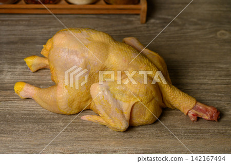 Whole Raw Yellow Chicken on Wooden Table Whole Raw Yellow Chicken on Wooden Table 142167494