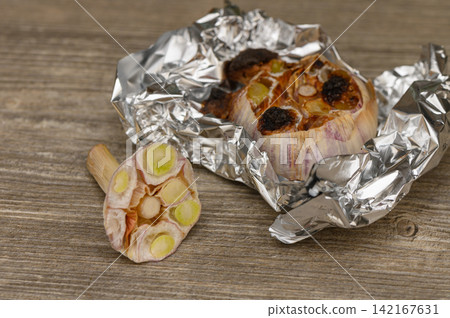 Roasted Garlic Head and Cross-Section Slice on Wood Roasted Garlic Head and Cross-Section Slice on Wood 142167631