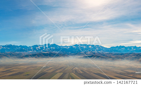 Aerial View of Snow-Capped Mountain Range and Hazy Valley Aerial View of Snow-Capped Mountain Range and Hazy Valley 142167721