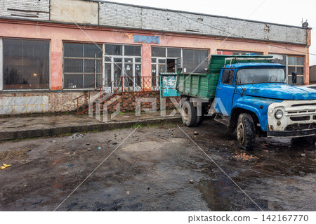 Weathered Blue Flatbed Truck in Abandoned Lot 142167770
