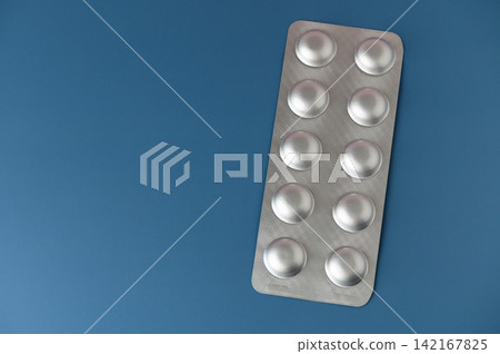 Medical tablets arranged neatly on a blue background, illustrating health and wellness at any time of day Medical tablets arranged neatly on a blue background, illustrating health and wellness at any time of day 142167825