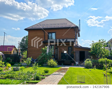 Wooden two story country house green garden sunny summer Wooden two story country house green garden sunny summer 142167906