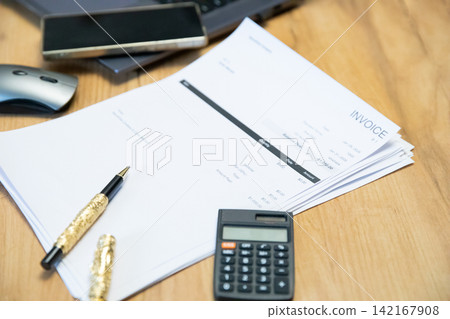 Wooden Desk With Laptop Keyboard And Financial Invoices Wooden Desk With Laptop Keyboard And Financial Invoices 142167908