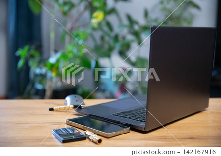 Black Laptop Smartphone And Calculator On Wooden Desk Black Laptop Smartphone And Calculator On Wooden Desk 142167916