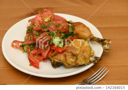 Roasted Chicken Pieces with Tomato Salad and Fork Roasted Chicken Pieces with Tomato Salad and Fork 142168015