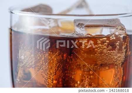 Refreshing cold cola soft drink with ice cubes and carbonation fizz 142168018