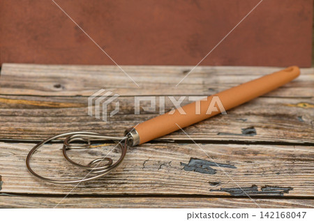 Danish Dough Whisk with Wooden Handle on Rustic Wooden Surface Danish Dough Whisk with Wooden Handle on Rustic Wooden Surface 142168047