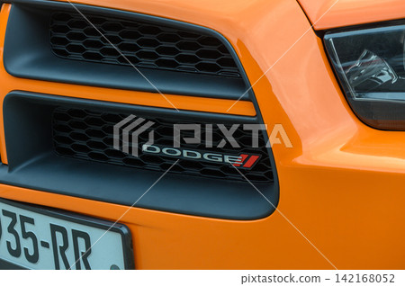 August 15, 2026, Tbilisi, Georgia Macro close-up of the front grille and Dodge emblem of an orange car August 15, 2026, Tbilisi, Georgia Macro close-up of the front grille and Dodge emblem of an orange car 142168052