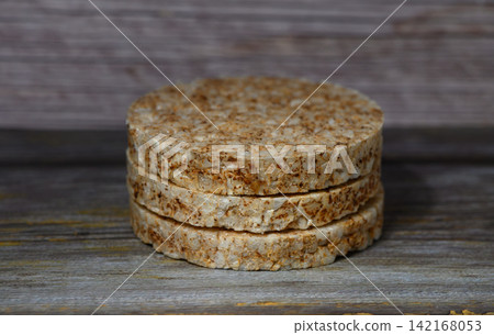 Stack of round rice cakes on a rustic wooden surface Stack of round rice cakes on a rustic wooden surface 142168053