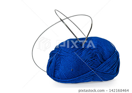 Bright blue yarn with a silver needle poised for creative stitching awaits an artist's gentle touch Bright blue yarn with a silver needle poised for creative stitching awaits an artist's gentle touch 142168464