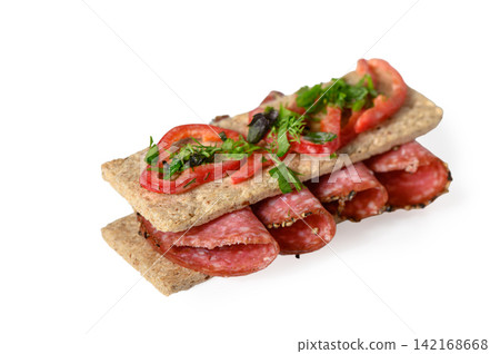 Appetizing crispbread sandwich with salami, sliced red pepper, and fresh herbs Appetizing crispbread sandwich with salami, sliced red pepper, and fresh herbs 142168668