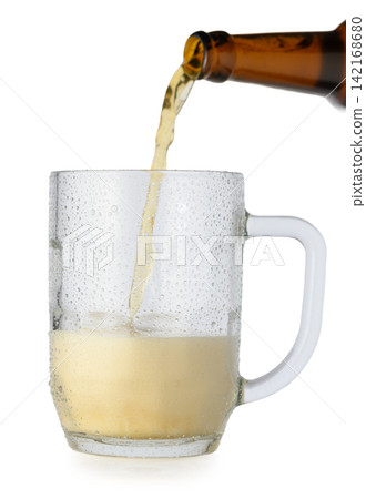 Pouring beer from a brown bottle into a wet, condensation-covered glass mug on a white background 142168680