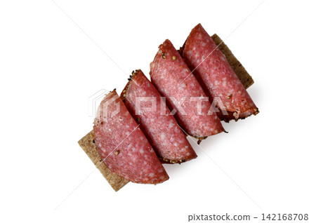 Crispbread slices topped with folded salami sausage slices 142168708