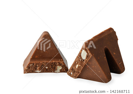 Two separated pieces of triangular milk chocolate with nougat and almonds isolated on a white background Two separated pieces of triangular milk chocolate with nougat and almonds isolated on a white background 142168711
