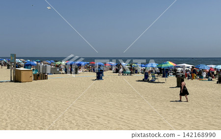 Beach Scene in Asbury Park With Many Umbrellas and People Enjoying Beach Scene in Asbury Park With Many Umbrellas and People Enjoying 142168990