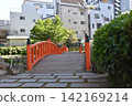 A riverside park and a red pedestrian bridge in Tokyo. 142169214