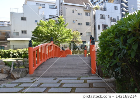 A riverside park and a red pedestrian bridge in Tokyo. A riverside park and a red pedestrian bridge in Tokyo. 142169214