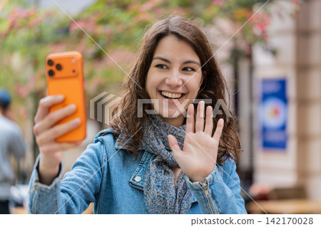 Young woman recording smartphone vlog walking in city street sharing travel story with happy smile Young woman recording smartphone vlog walking in city street sharing travel story with happy smile 142170028