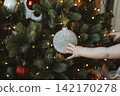 Child Reaching for Ornament on Christmas Tree 142170278