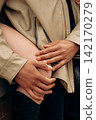 Hands Gently Holding Knee in Warm Interpersonal Gesture 142170279