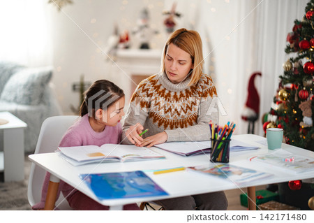 Mother and daughter studying at home during winter holidays 142171480