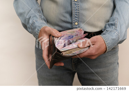 Open wallet with colorful banknotes Ukrainian hryvnia visible, Open wallet with colorful banknotes Ukrainian hryvnia visible, 142171669