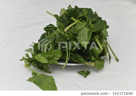 Green spinach with tasty parsley bunch sits on kitchen table. Green spinach with tasty parsley bunch sits on kitchen table. 142171690