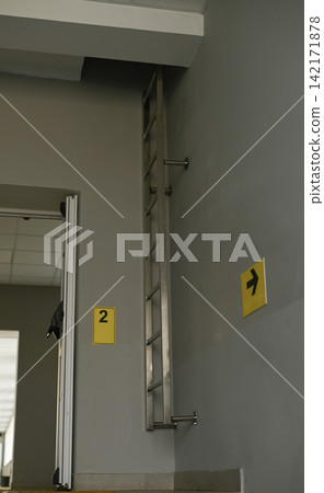 Indoor metal fire ladder mounted on wall, 142171878