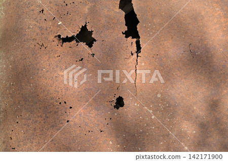 Rusty metal surface with corrosion and dark holes shows aged industrial texture, Rusty metal surface with corrosion and dark holes shows aged industrial texture, 142171900