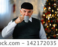 Senior man enjoying hot coffee during festive holiday season 142172035